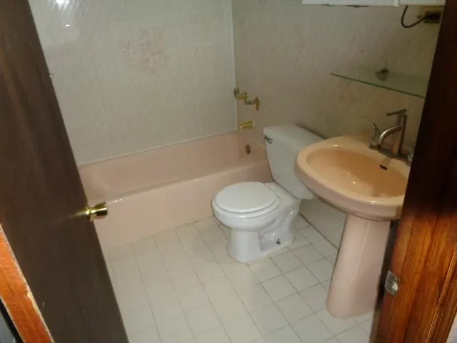 a white toilet sitting next to a bath tub