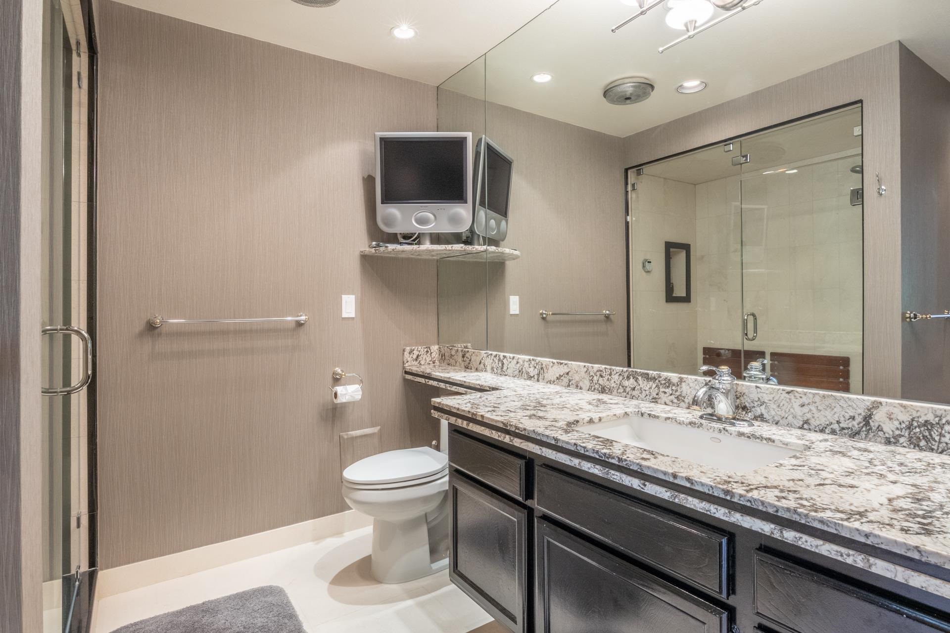 623 Golden Creek Road, Unit 623 Mammoth Lakes, CA 93546 - Photo 20 of 33 a bathroom with a granite countertop sink a toilet and shower
