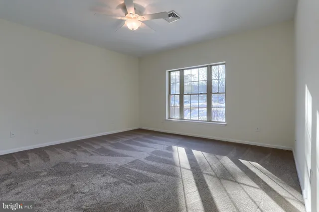 a view of an empty room and window chandelier fan