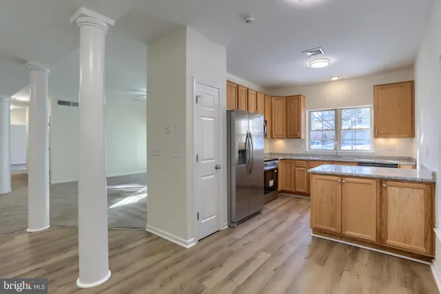 a kitchen with stainless steel appliances a refrigerator and wooden cabinets
