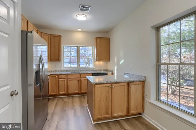 a kitchen with a refrigerator and wooden cabinets