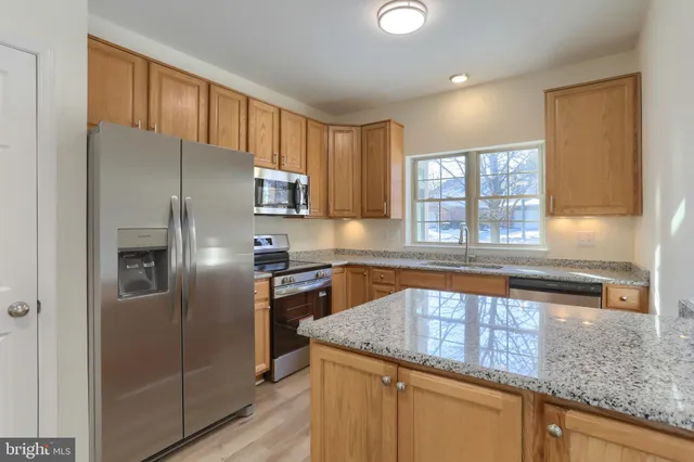 a kitchen with a refrigerator a sink and cabinets