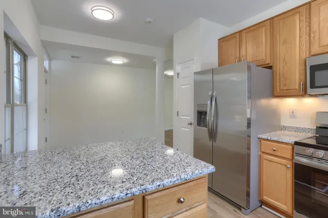 a kitchen with stainless steel appliances granite countertop a refrigerator and a sink