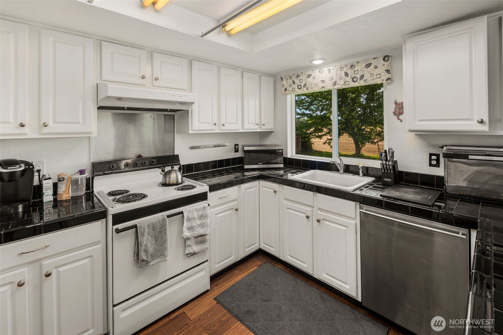 17464 Dunbar Road, Unit 1 Mount Vernon, WA 98273 - Photo 4 of 40 a white kitchen with granite countertop a stove top oven sink and cabinets