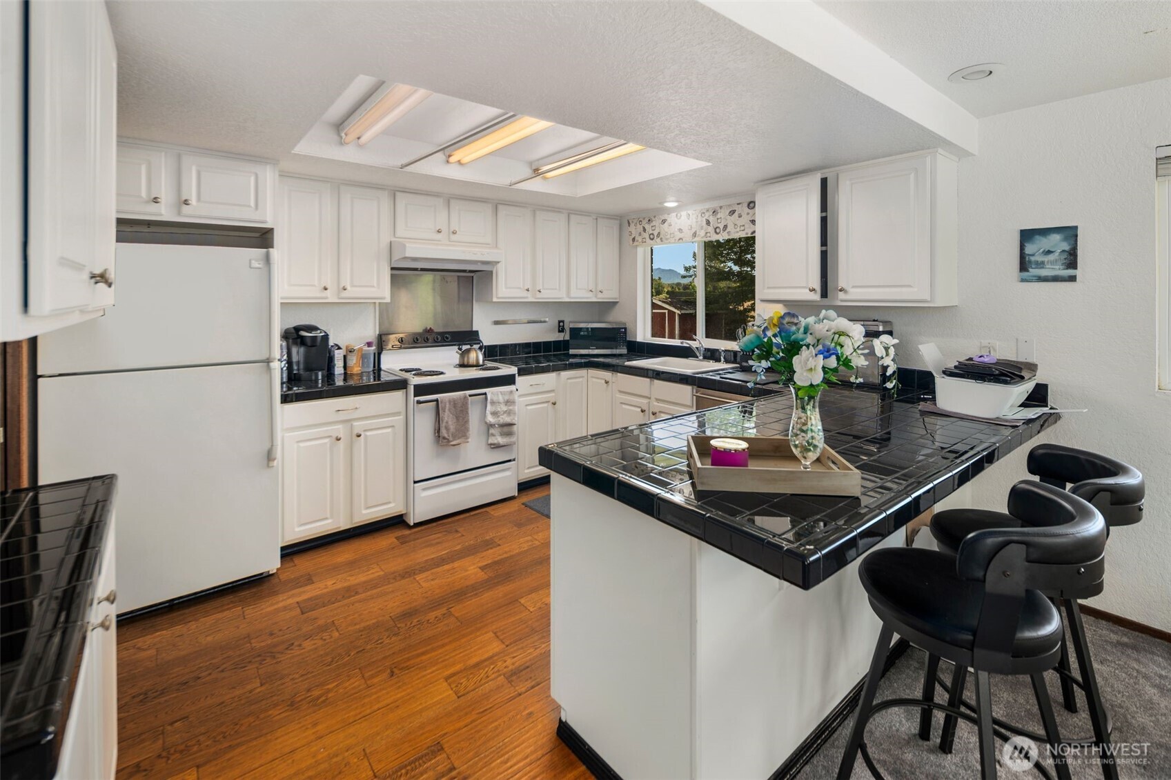 17464 Dunbar Road, Unit 1 Mount Vernon, WA 98273 - Photo 6 of 40 a kitchen with a stove a refrigerator and a dining table