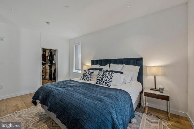 a bedroom with a bed and a lamp on desk