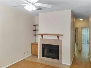 a view of a livingroom with a fireplace and chandelier fan