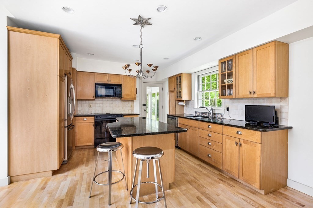 59 Cottage Street Hingham, MA 02043 - Photo 5 of 28 a kitchen with stainless steel appliances granite countertop a stove top oven a sink dishwasher a dining table and chairs with wooden floor