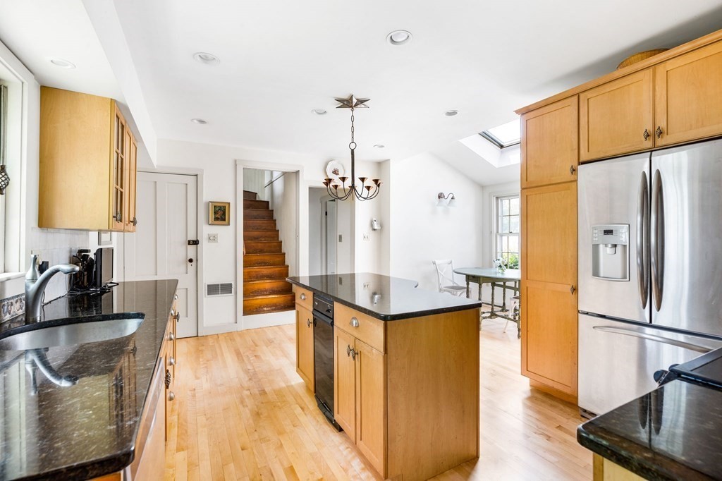 59 Cottage Street Hingham, MA 02043 - Photo 6 of 28 a kitchen with stainless steel appliances granite countertop a refrigerator a sink dishwasher a stove and a dining table with wooden floor