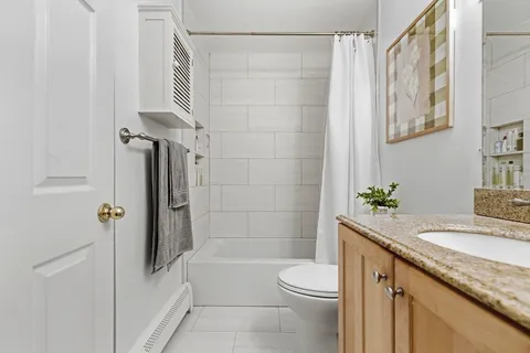 a bathroom with a granite countertop sink toilet and shower