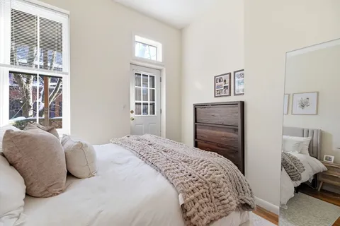 a bedroom with a bed and wooden floor