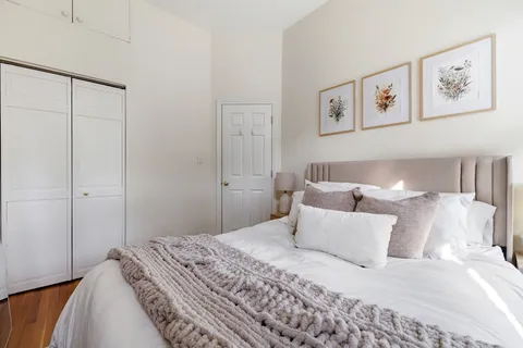 a bedroom with a bed and painting on the wall