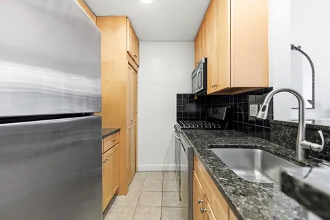 a kitchen with a granite countertop sink a refrigerator and a stove