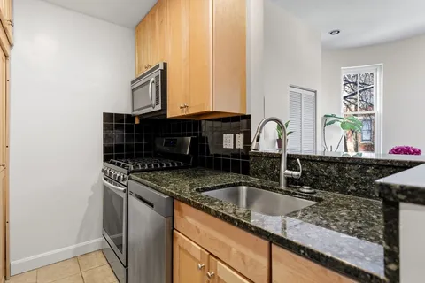 a kitchen with granite countertop a sink and a stove