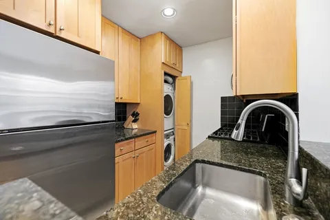 a kitchen with a sink a refrigerator and cabinets