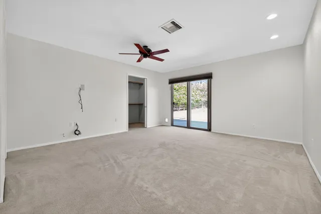 a bedroom with a bed a couch and a potted plant