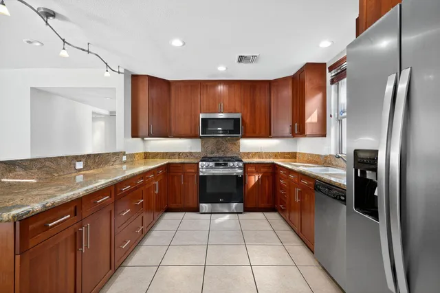 a bathroom with a granite countertop sink a mirror and bathtub
