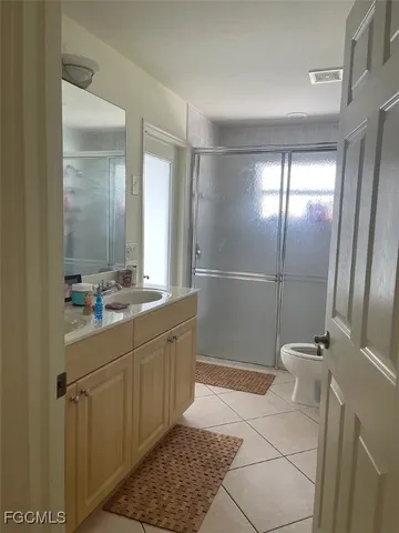 a bathroom with a double vanity sink a toilet and a mirror