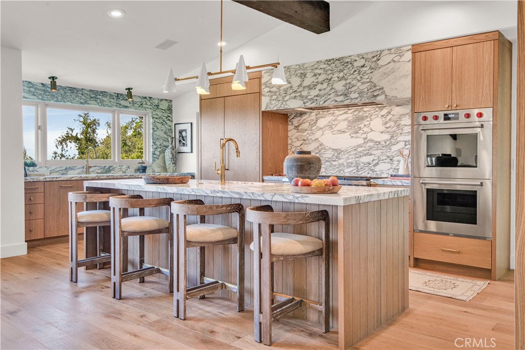 a kitchen with kitchen island granite countertop a table chairs sink and cabinets
