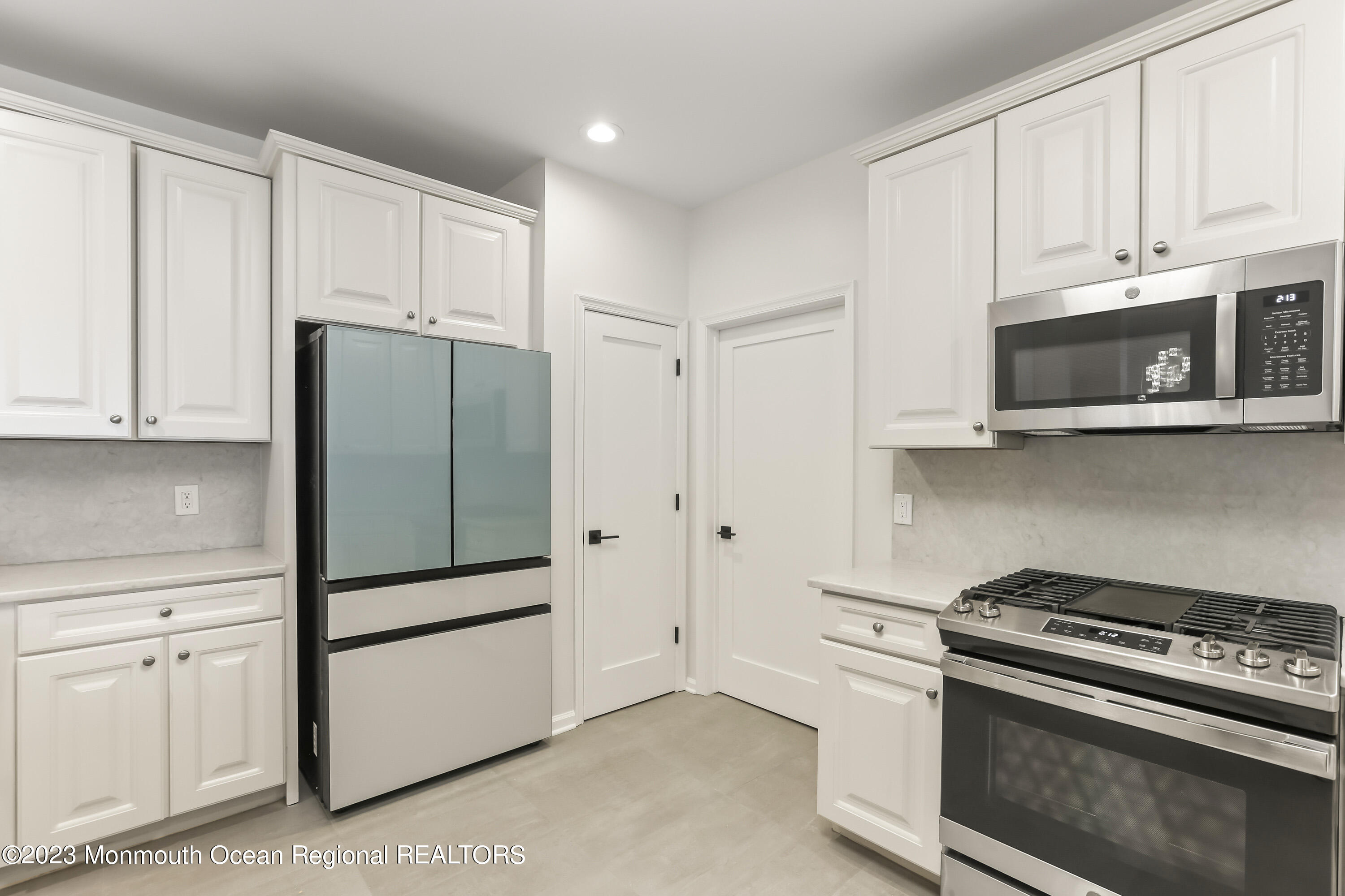 22 Cooper Avenue, Unit 309 Long Branch, NJ 07740 - Photo 11 of 52 a kitchen with stainless steel appliances white cabinets and a stove top oven