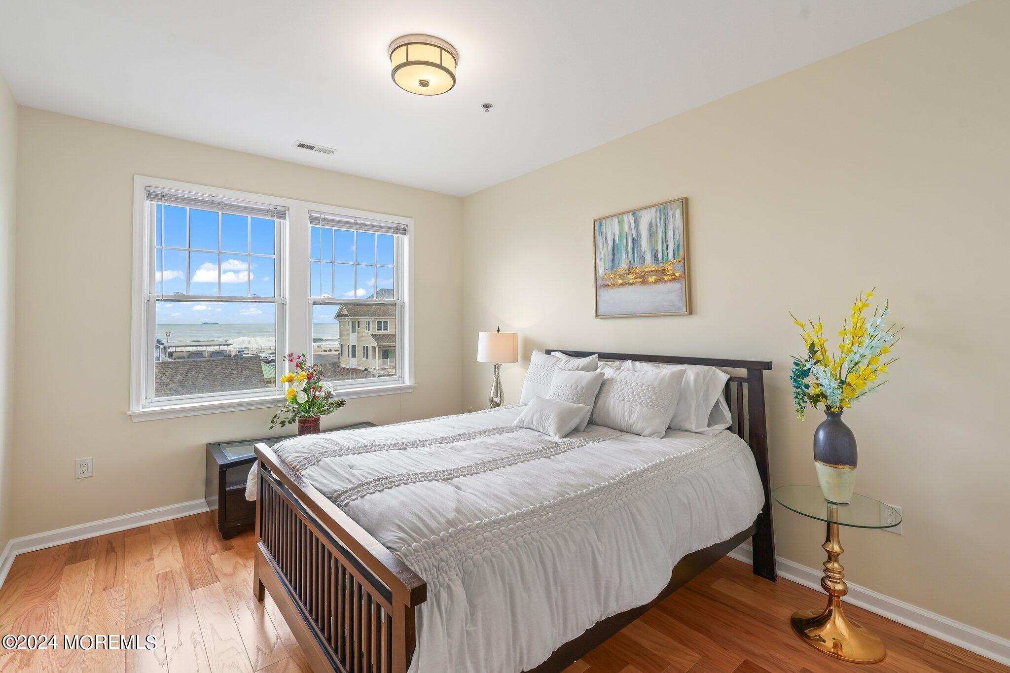 22 Cooper Avenue, Unit 309 Long Branch, NJ 07740 - Photo 17 of 52 a bed sitting in a bedroom next to a window