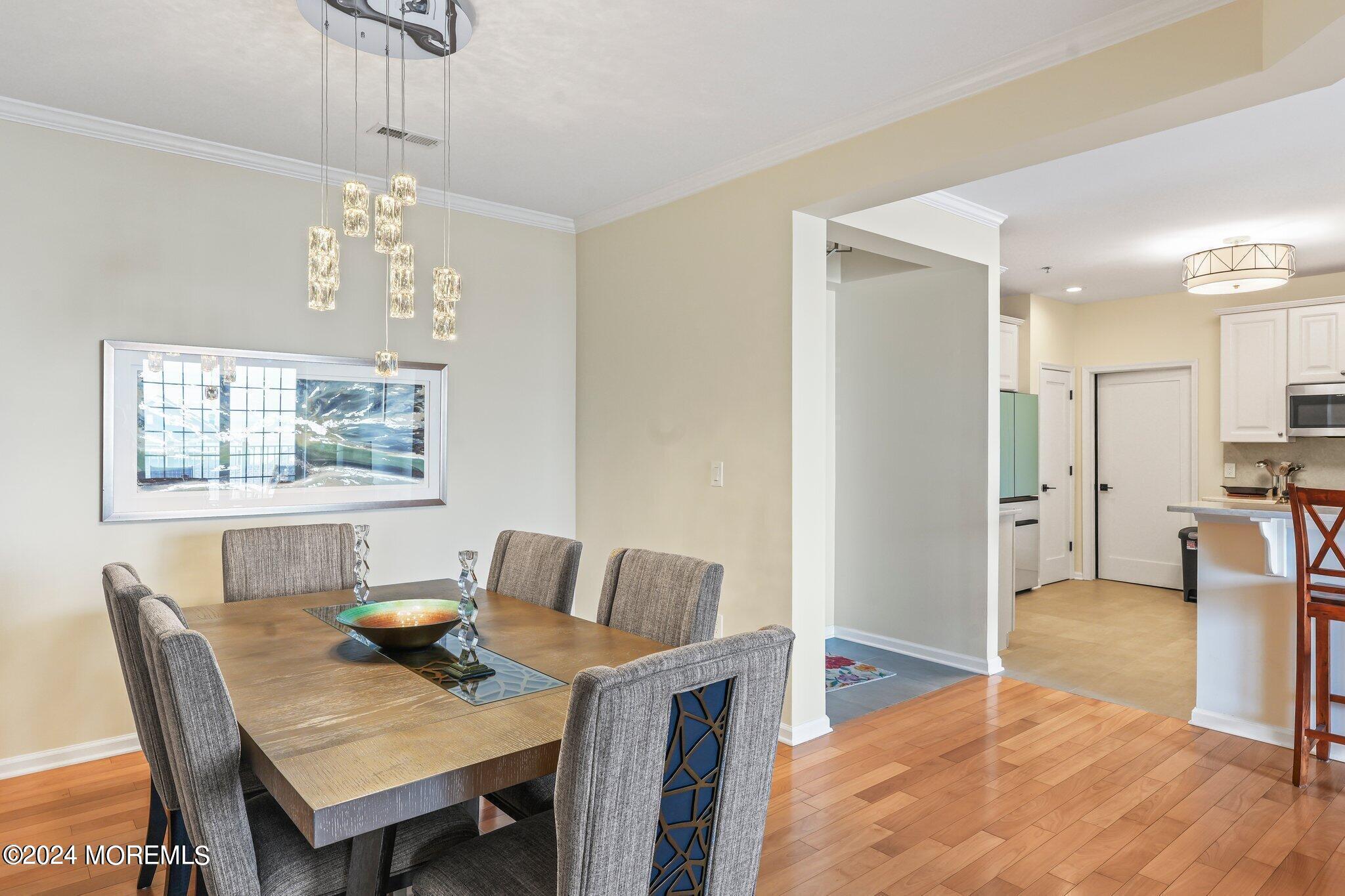 22 Cooper Avenue, Unit 309 Long Branch, NJ 07740 - Photo 7 of 52 a view of a dining room with furniture a chandelier and wooden floor