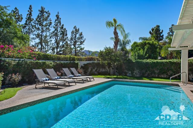 a view of a swimming pool with a table and chairs in patio
