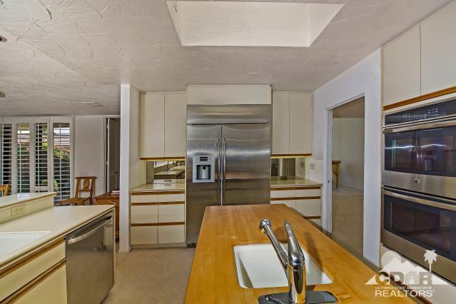 6 Exeter Court Rancho Mirage, CA 92270 - Photo 7 of 20 a kitchen with kitchen island a counter top space stainless steel appliances and a refrigerator
