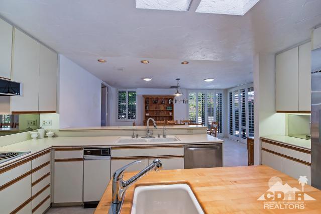 6 Exeter Court Rancho Mirage, CA 92270 - Photo 8 of 20 a kitchen with stainless steel appliances kitchen island granite countertop a sink and cabinets