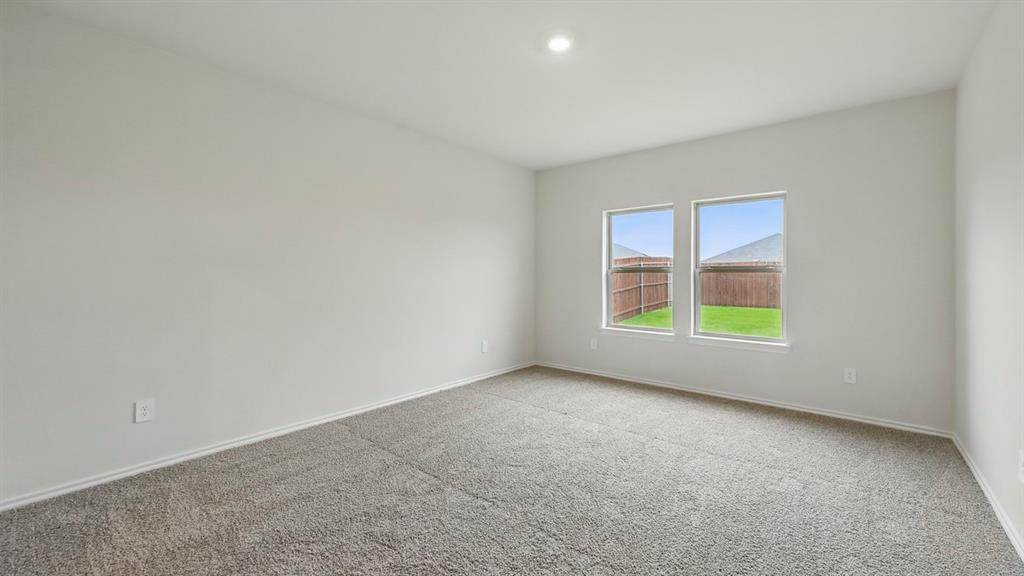 232 Pheasant Run Road Terrell, TX 75160 - Photo 8 of 36 Spacious room with plush gray carpeting, two large windows, white walls, and recessed lighting