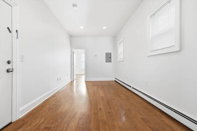 a view of an empty room with wooden floor