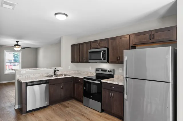 a kitchen with a refrigerator sink and wooden floor