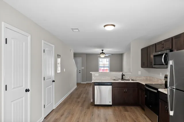 a kitchen with granite countertop a sink cabinets and stainless steel appliances