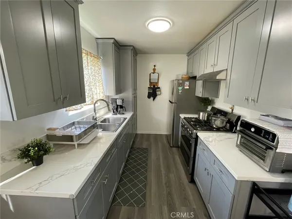 a kitchen with granite countertop lots of counter top space a sink and stainless steel appliances
