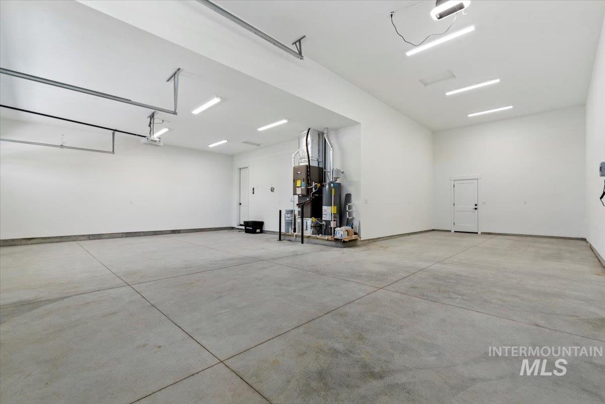 2391 East Snocreek Drive Eagle, ID 83616 - Photo 25 of 29 Garage featuring water heater and a garage door opener