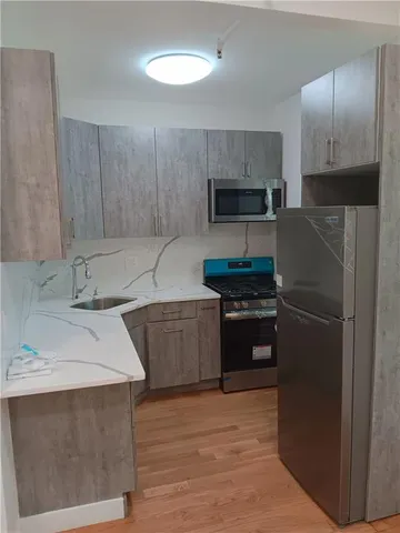 a kitchen with granite countertop a refrigerator and a sink