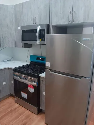a kitchen with stainless steel appliances a refrigerator stove and microwave