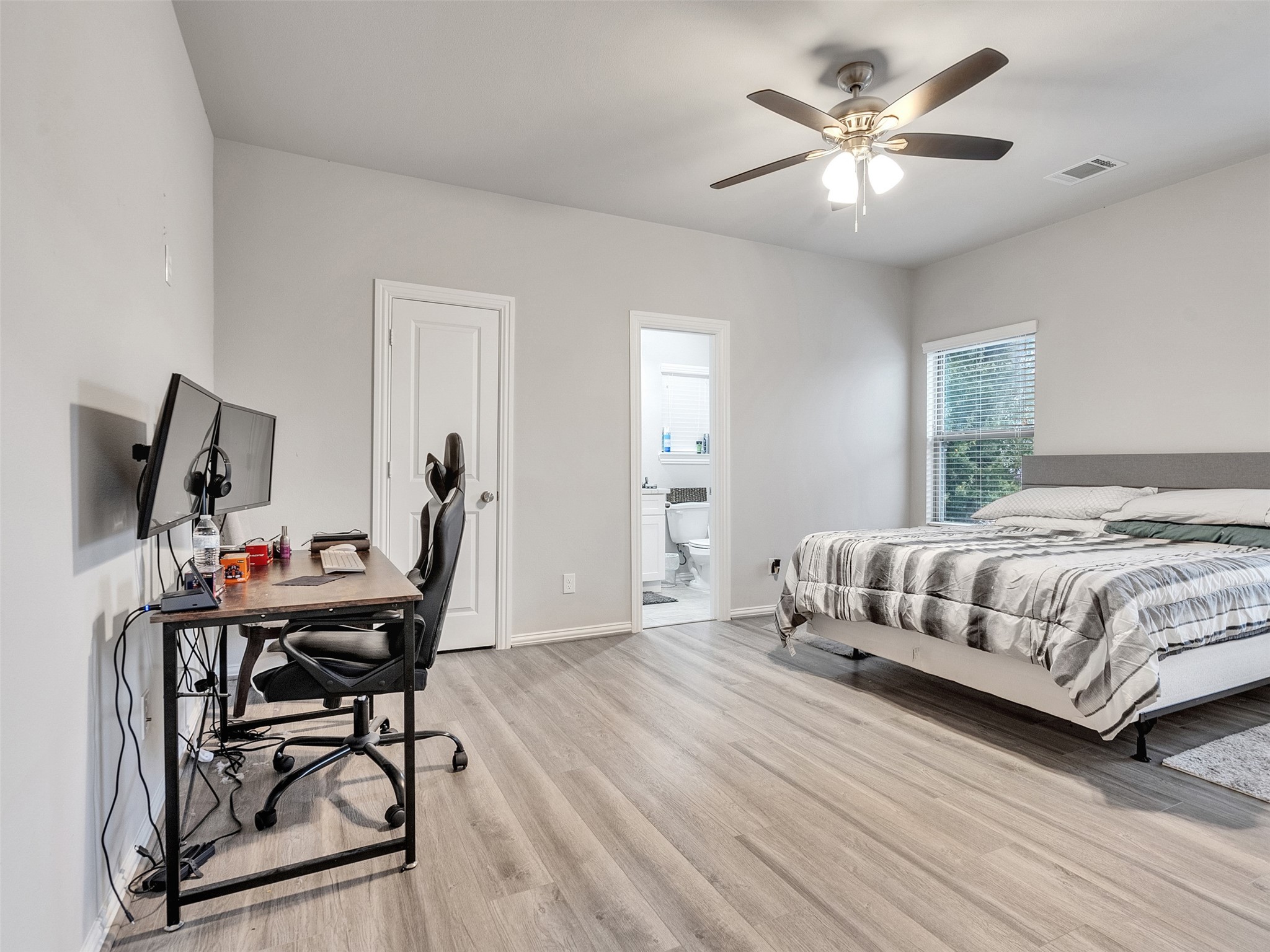 2411 Charles Road, Unit A Houston, TX 77093 - Photo 14 of 33 a bedroom with a bed a desk and chair with wooden floor