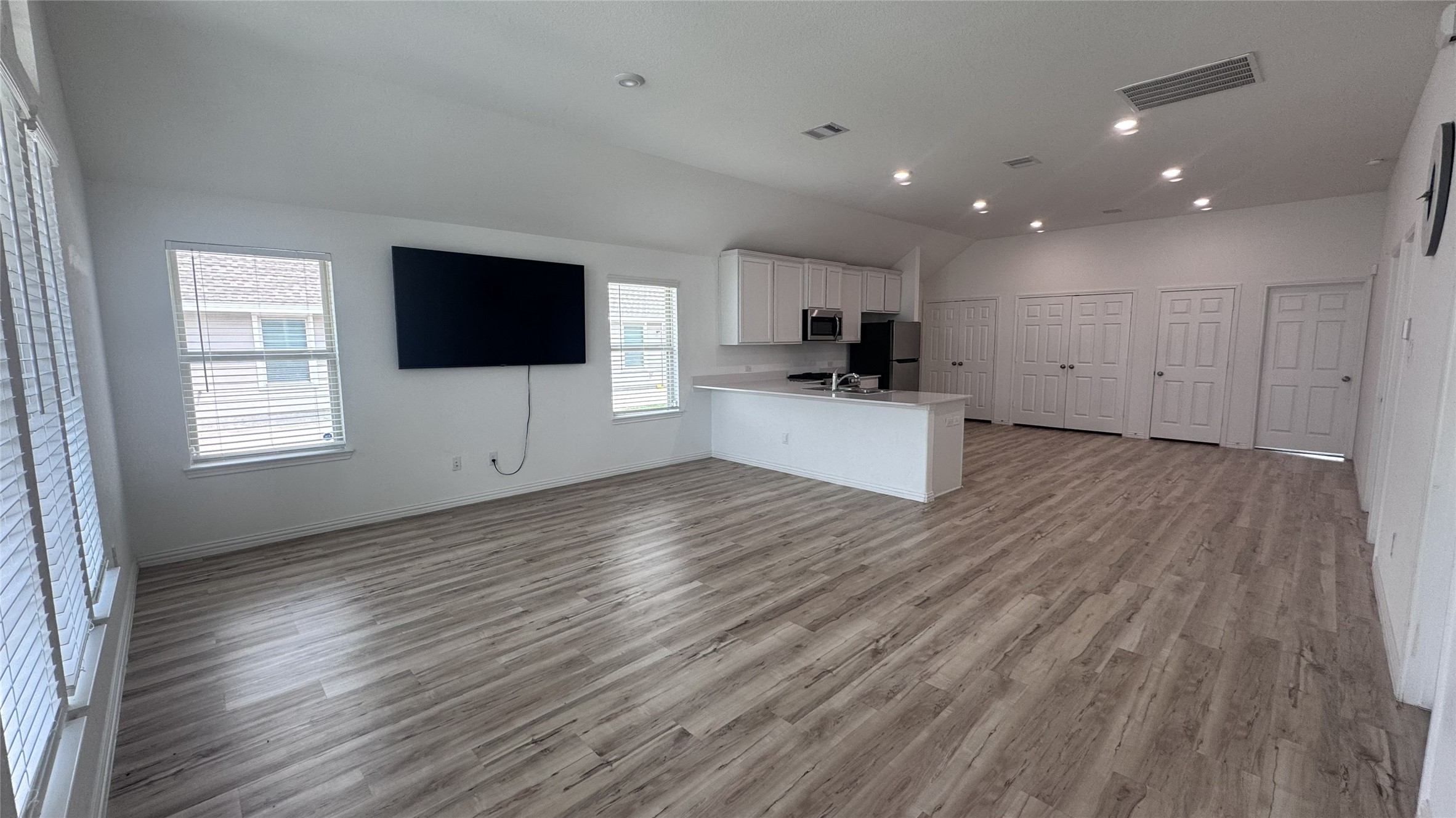 15746 Harding Bend Drive Humble, TX 77346 - Photo 3 of 18 a view of a kitchen and an empty room with wooden floor and windows