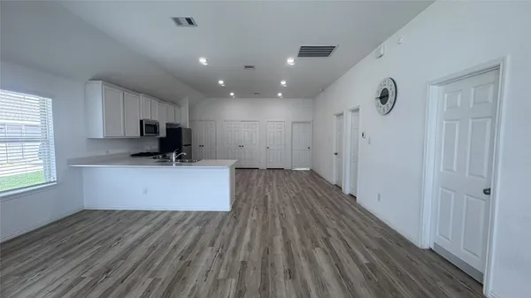 a view of kitchen with wooden floor and electronic appliances