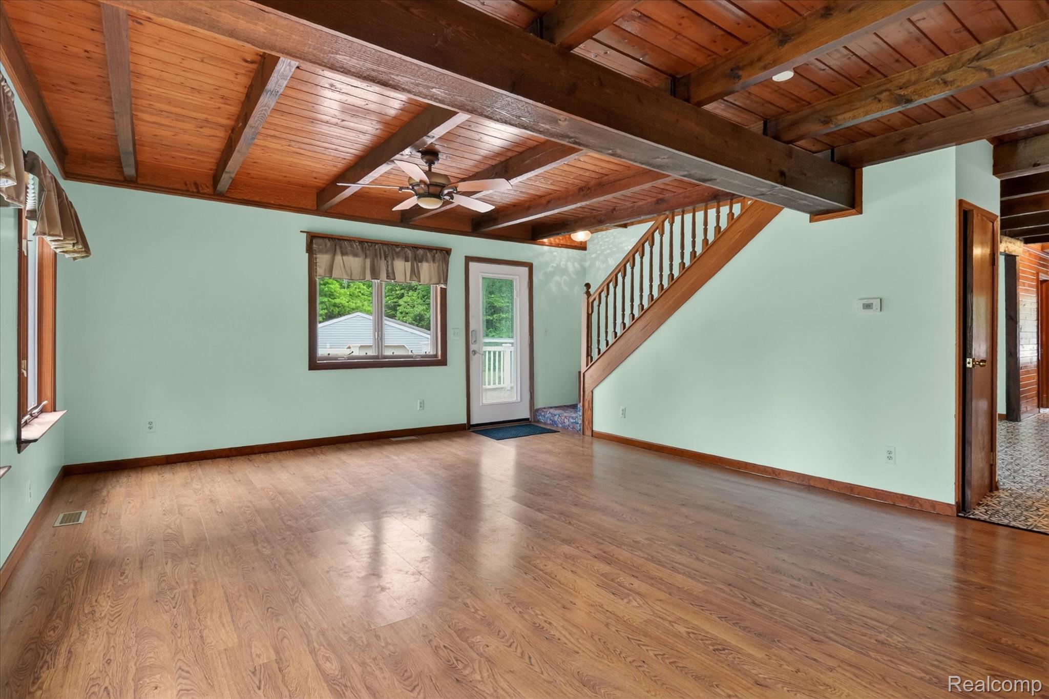 41303 Harris Road Belleville, MI 48111 - Photo 11 of 49 Unfurnished living room with light wood finished floors, ceiling fan, and a wood ceiling with exposed beams