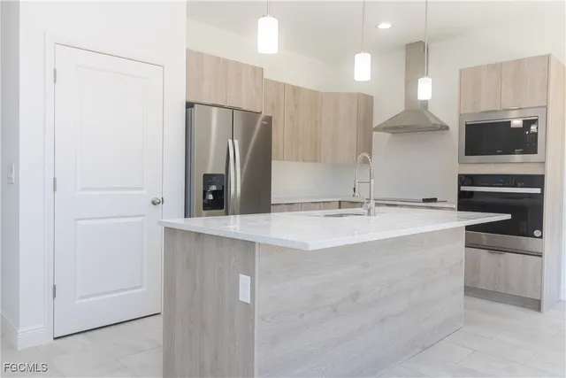 a view of a kitchen with kitchen island a sink stainless steel appliances and cabinets