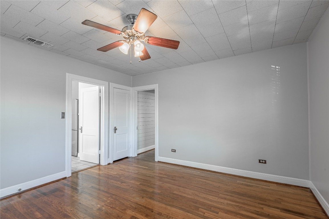 1415 22nd Street Huntsville, TX 77340 - Photo 15 of 30 an empty room with wooden floor and ceiling fan