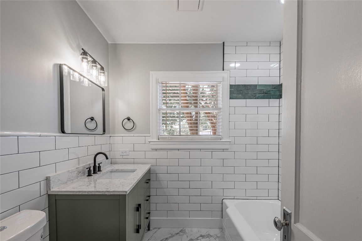 1415 22nd Street Huntsville, TX 77340 - Photo 16 of 30 a bathroom with a granite countertop toilet a sink and mirror