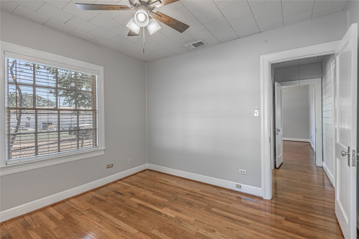 1415 22nd Street Huntsville, TX 77340 - Photo 19 of 30 a view of an empty room with wooden floor and a window