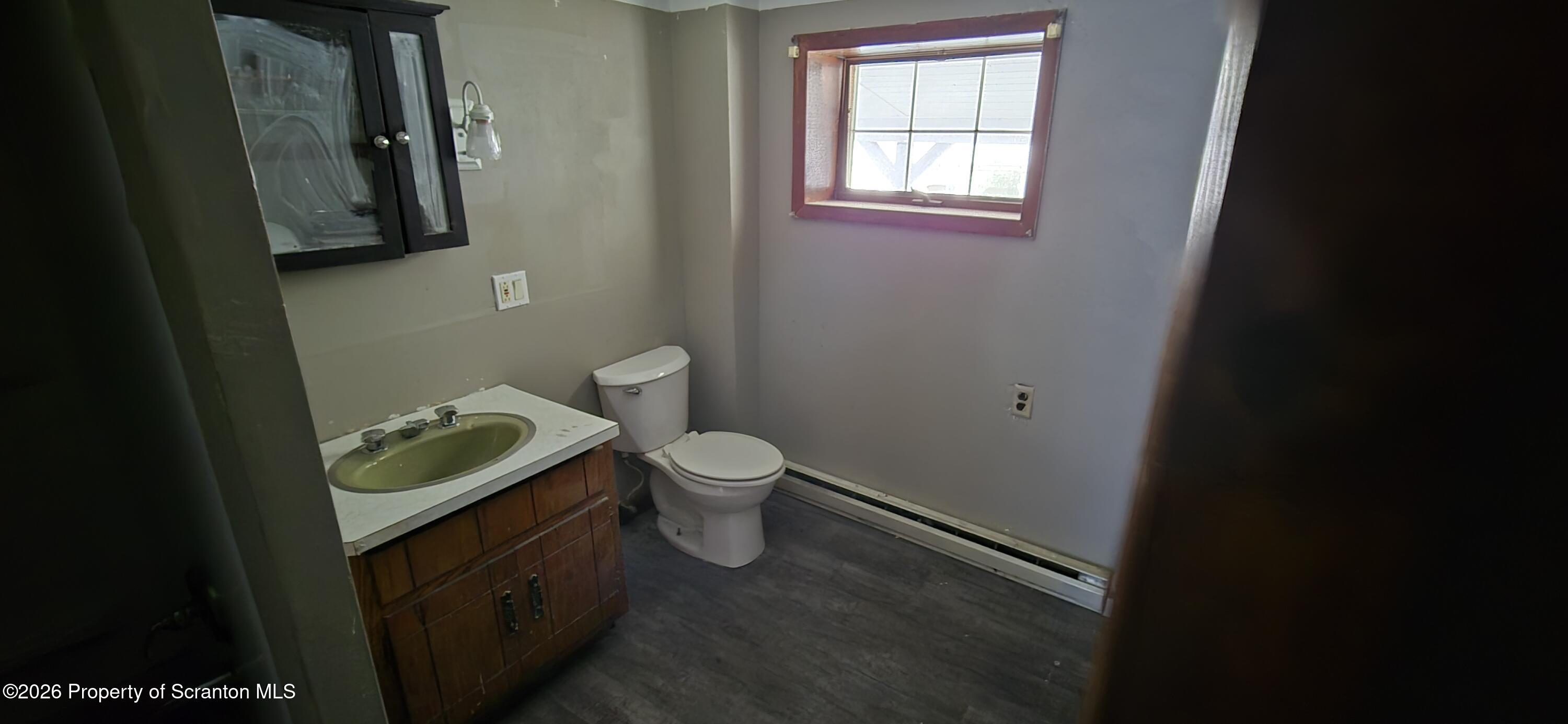 1140-1142 Academy Street Scranton, PA 18504 - Photo 16 of 49 a white toilet sitting next to a bathroom sink