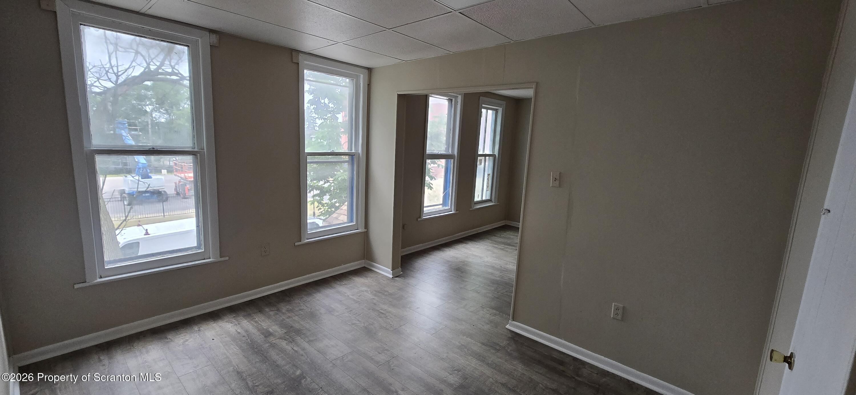 1140-1142 Academy Street Scranton, PA 18504 - Photo 27 of 49 an empty room with wooden floor and windows