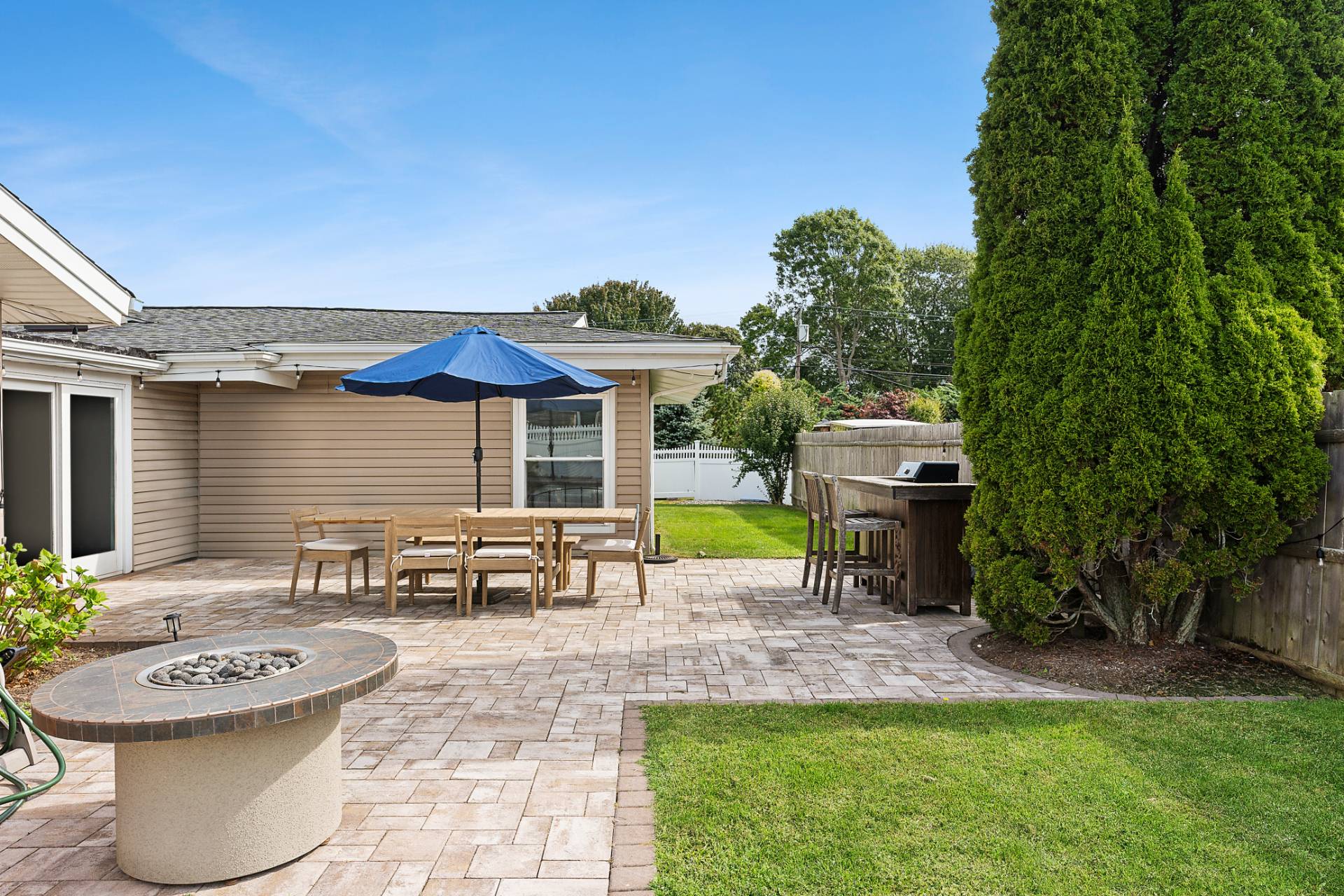 1 Shadbush Road Montauk, NY 11954 - Photo 18 of 19 a view of a patio with table and chairs potted plants and a palm tree