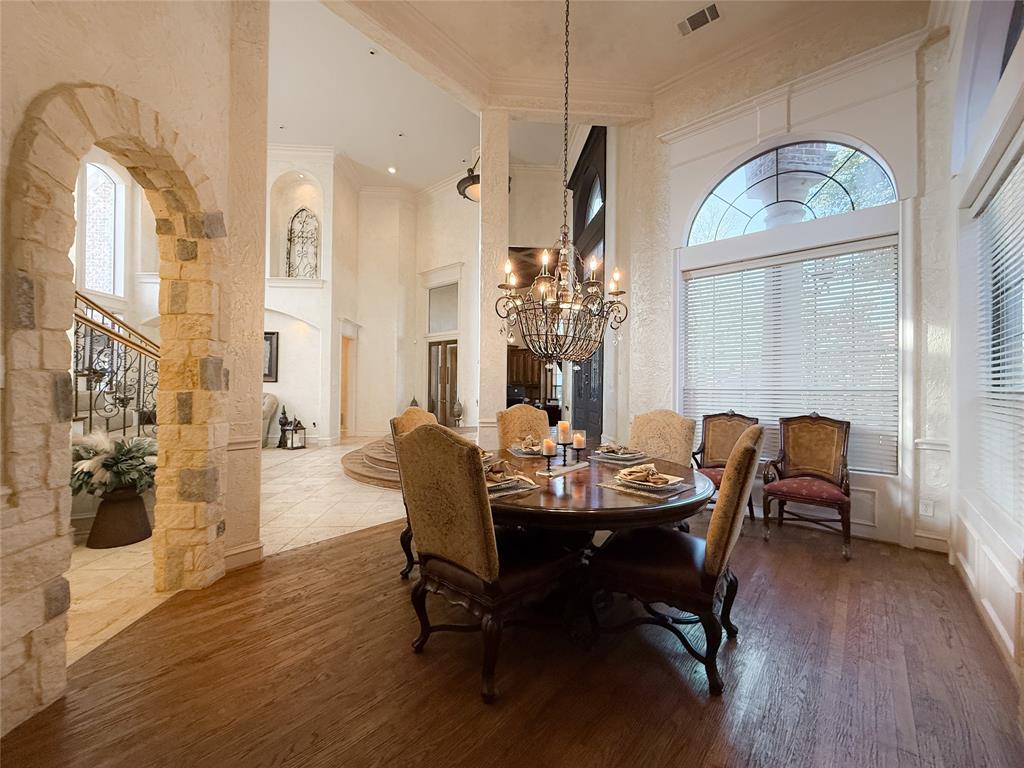1919 Kings Pass Heath, TX 75032 - Photo 7 of 38 Dining area with a high ceiling, arched walkways, crown molding, suspended lighting, and hardwood / wood-style floors