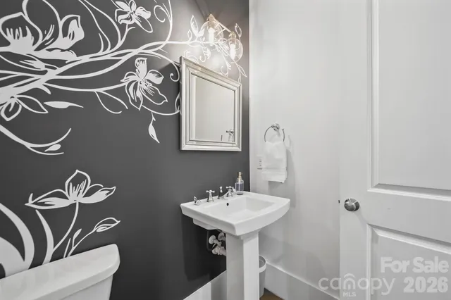 a bathroom with a sink and mirror with toilet